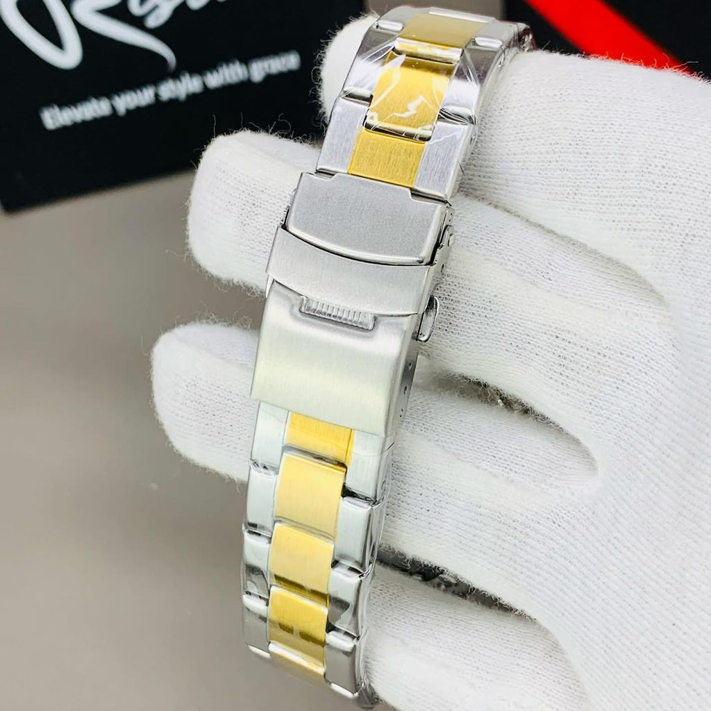 Silver and gold watch on a white glove with 'Risto' branding in the background.