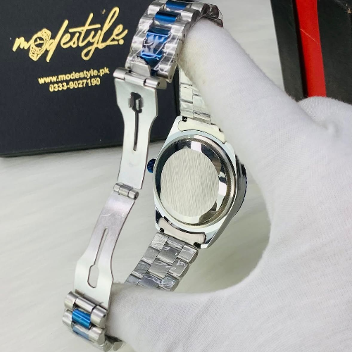 Silver watch with blue accents on a white surface, brand 'modestyle' visible.